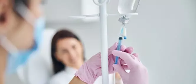 медсестра готовит капельницу для пациентки с кожным заболеванием